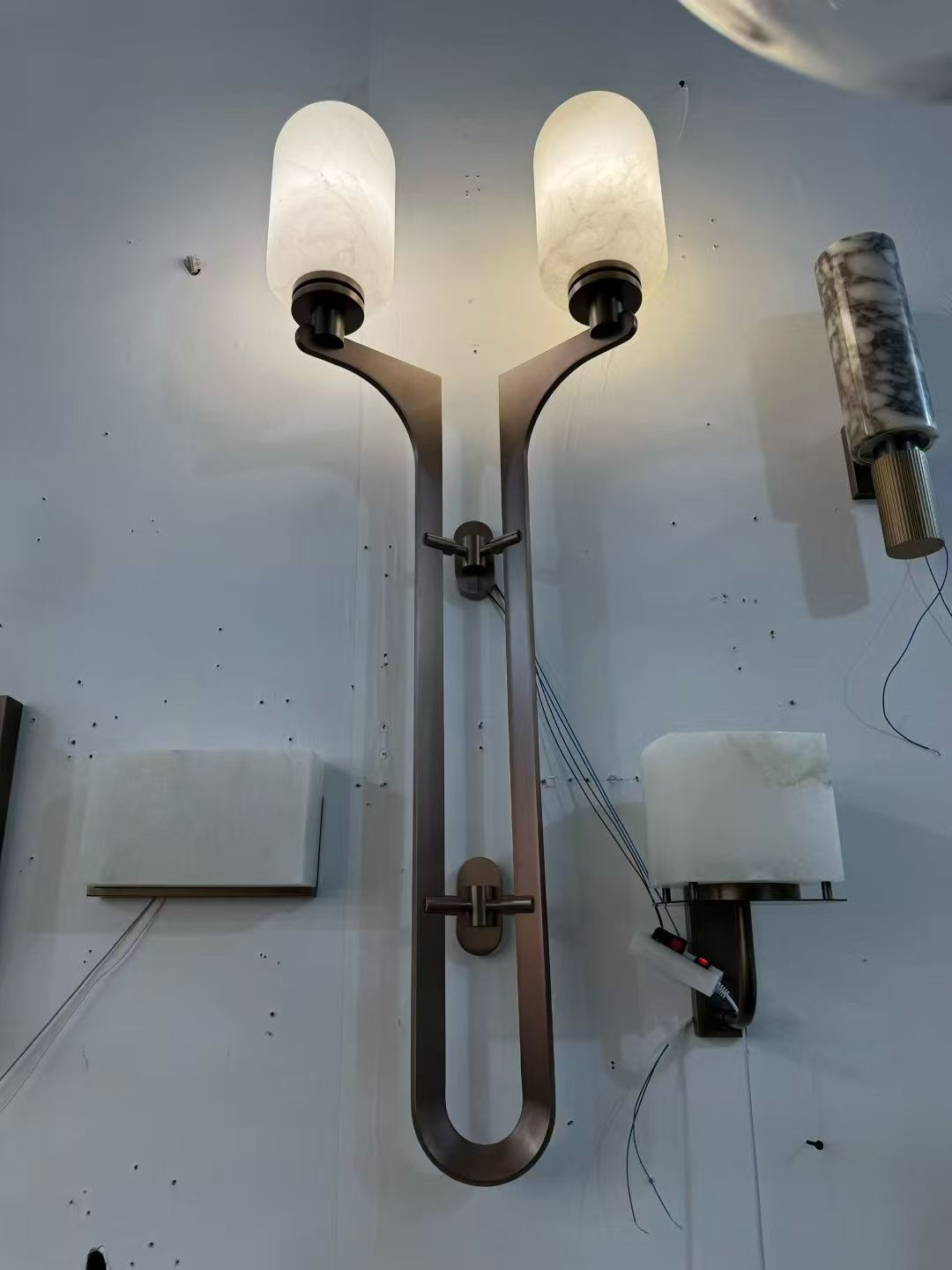Double-arm wall light with two illuminated shades in the workshop