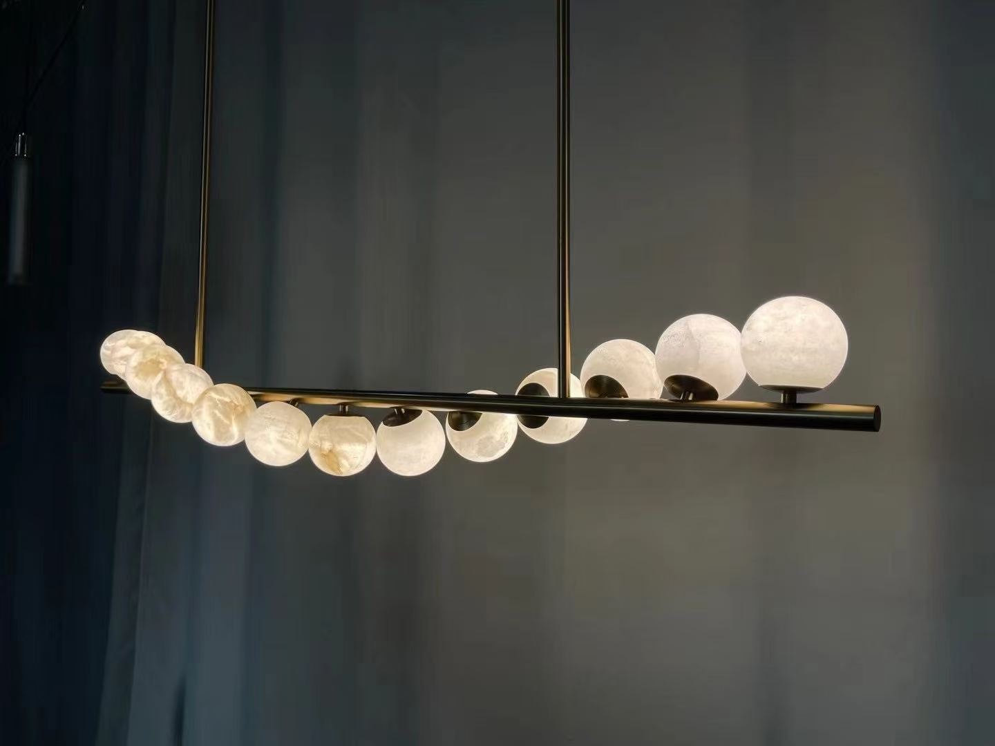 Linear pendant with illuminated stone spheres during workshop testing