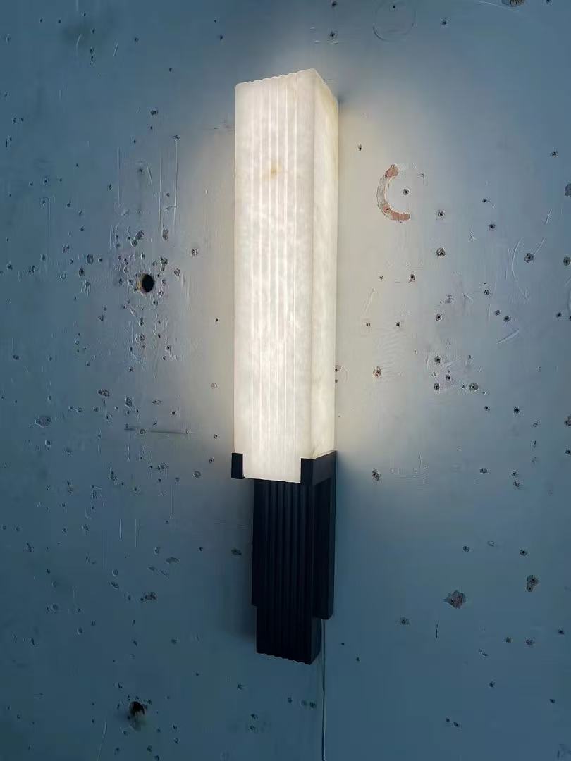 Vertical ribbed wall sconce with dark metal base in the workshop