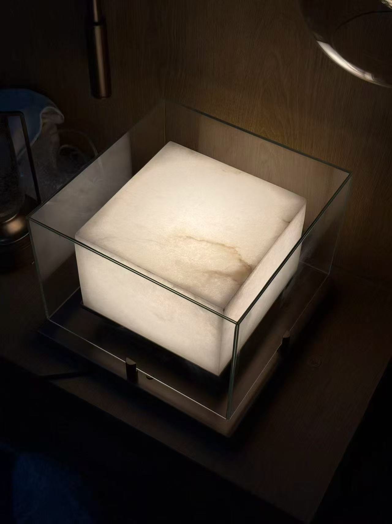 Luminous pale cube enclosed by a clear square glass frame in the workshop