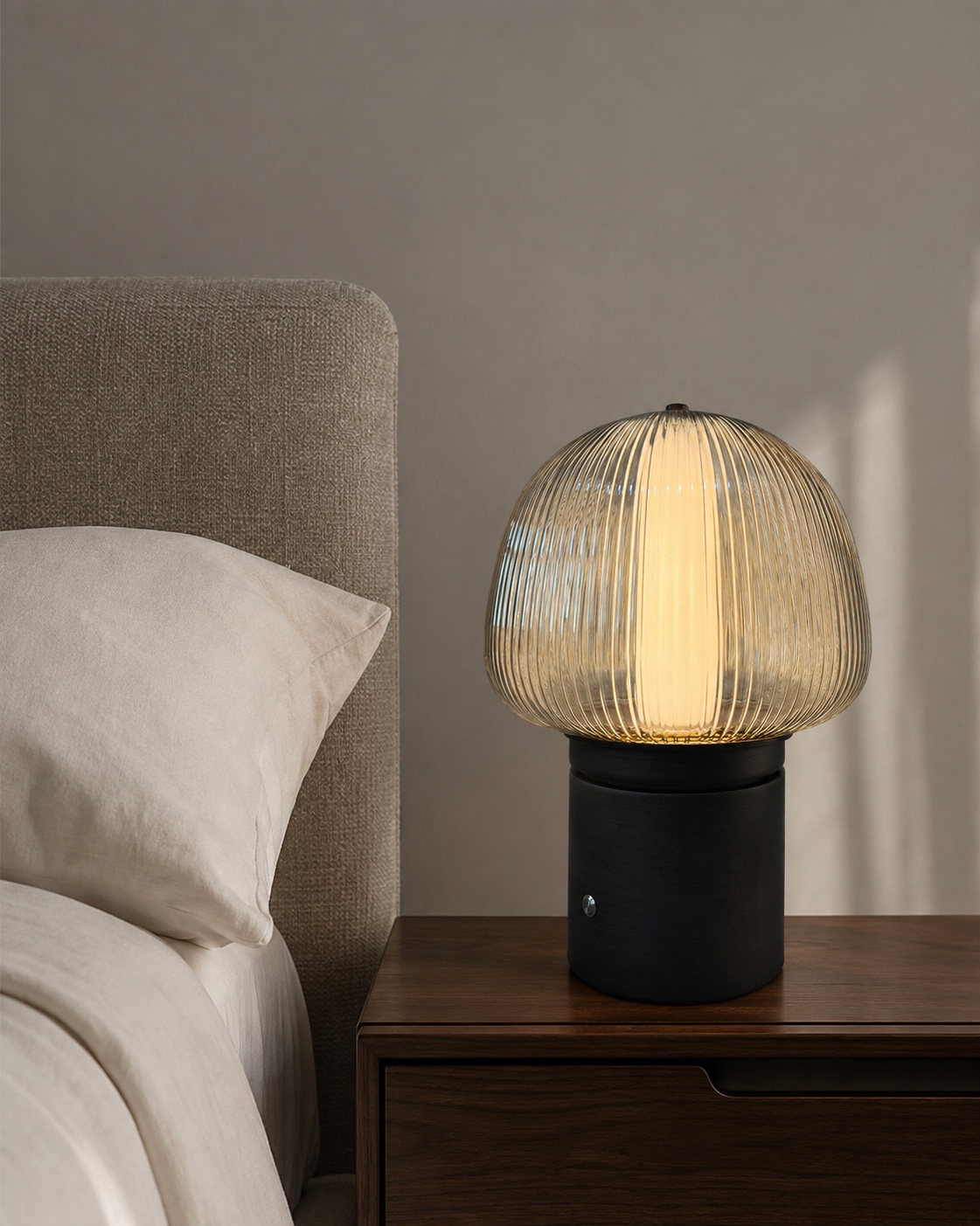 Bedside visualisation featuring a compact ribbed glass light on a dark cylindrical base