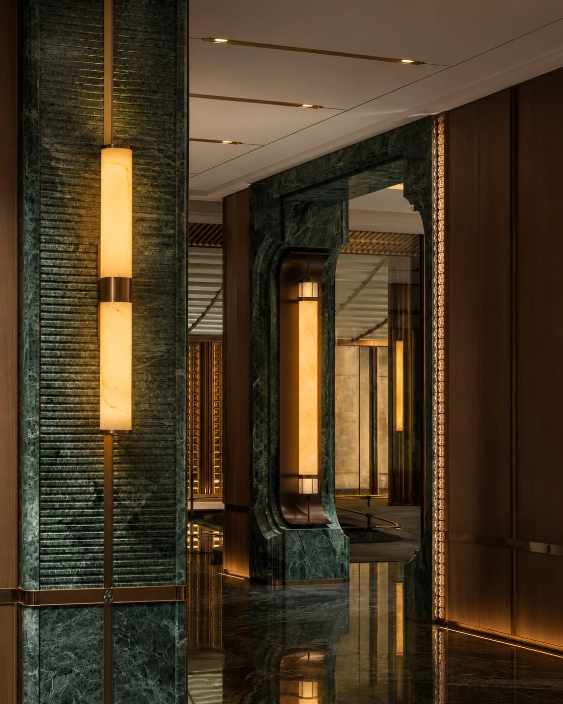 Vertical wall lights integrated with green stone and warm-toned interior finishes