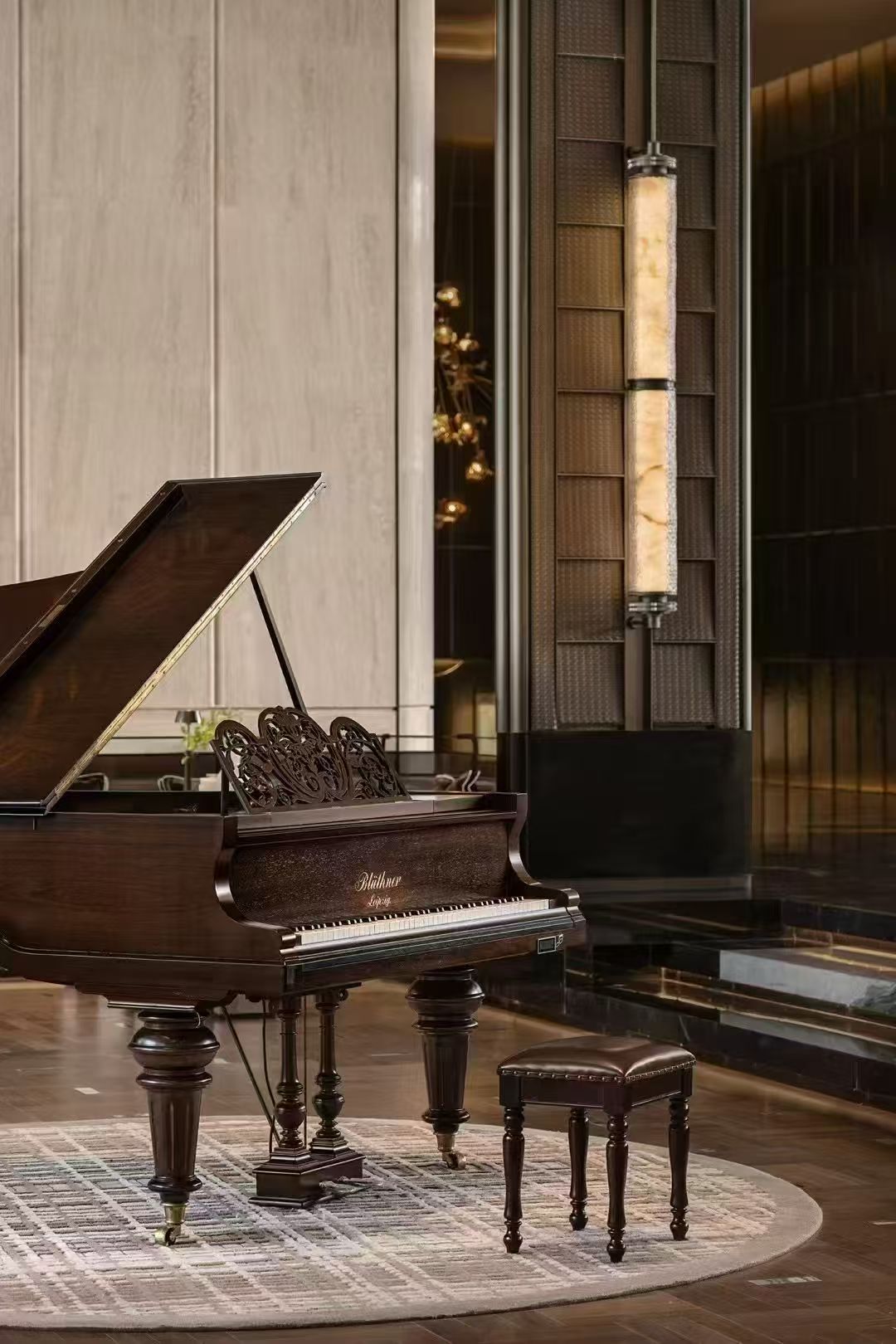 Slender vertical illuminated feature beside a grand piano