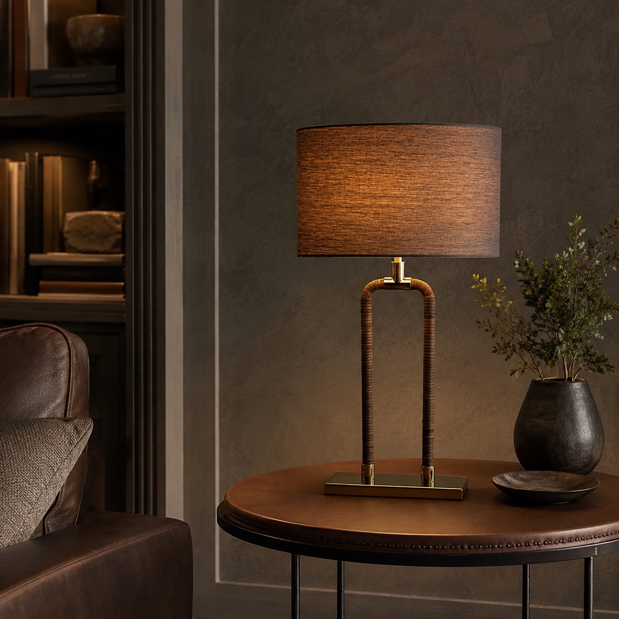 Custom table lamp with a leather-wrapped open frame, brass details and dark fabric shade